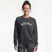 A person wearing a grey yoga sweater with the text “RELAX” on the chest.